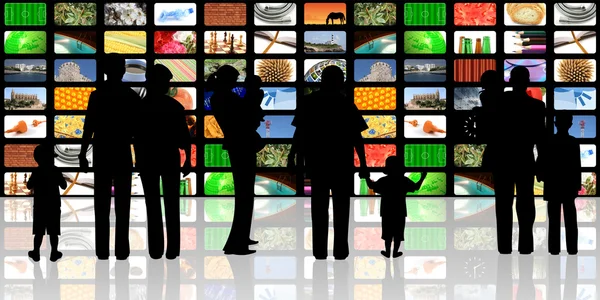 Jovem com crianças assistindo televisão no enorme painel lcd — Fotografia de Stock