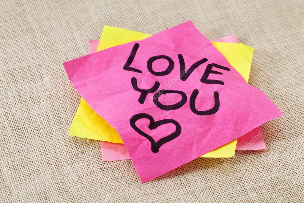 Office romance concept - love you text handwritten on red sticky note.