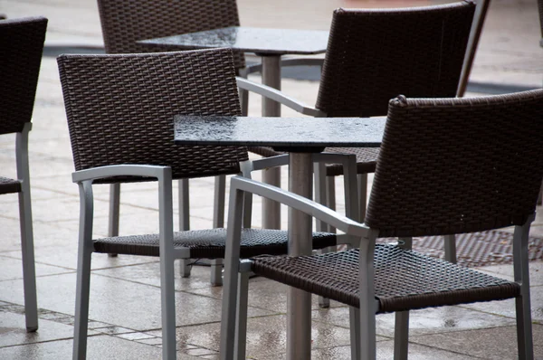 Våt stolar och bord utanför café — Stockfoto