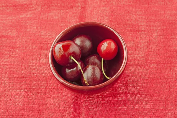 Cherries over red — Stock Photo, Image