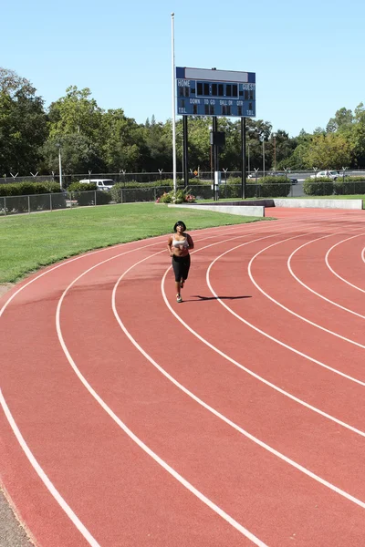 Jovem mulher negra correndo na pista tiro longo — Fotografia de Stock