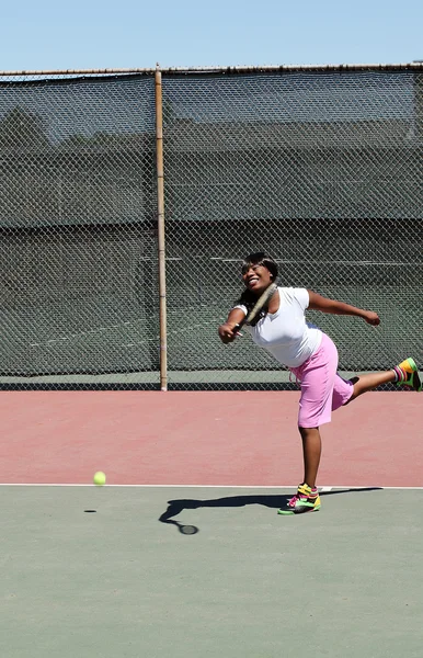Uśmiechający się czarna kobieta kołysanie przekręt tenisa na korcie — Zdjęcie stockowe
