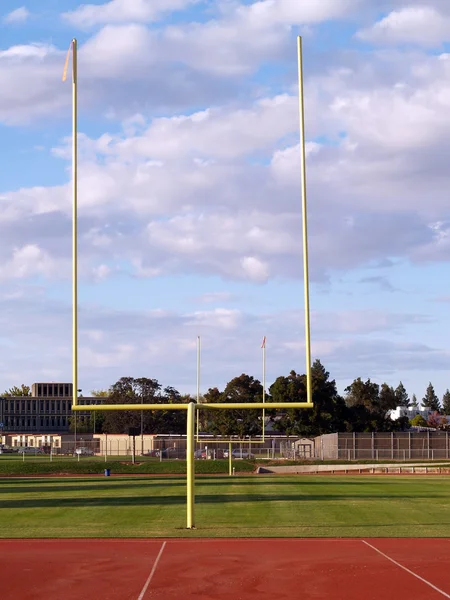 Doelpalen leeg voetbal veld wolken en blauwe hemel — Stockfoto