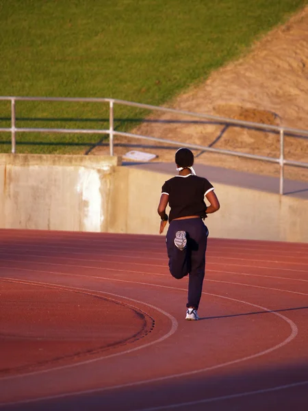 Jovem afro-americana correndo na pista — Fotografia de Stock