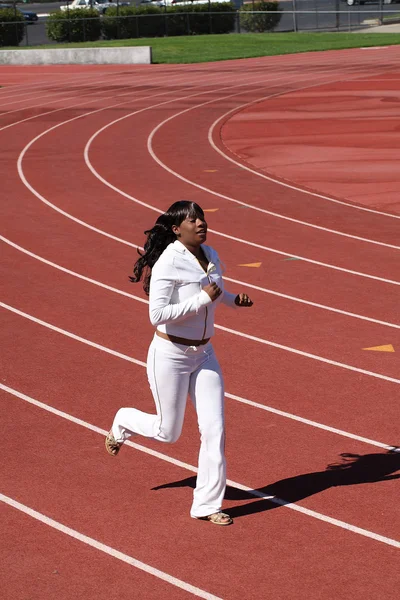 Young black woman running on track sweat suit — Stock Photo, Image