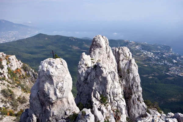 Wysokie skały z krzyżem przed morzem i lasem — Zdjęcie stockowe