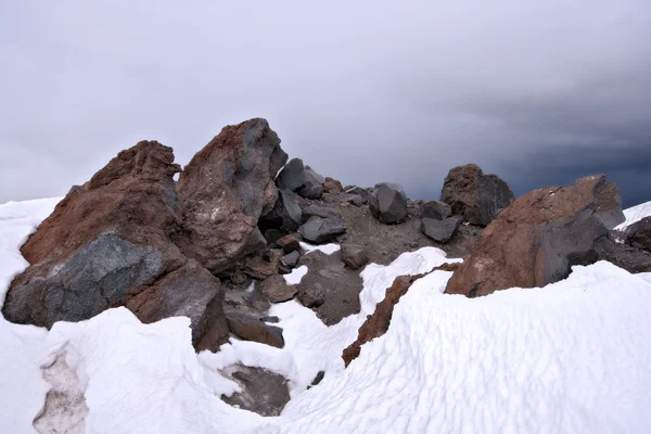 Rochers dans la neige contre un ciel bleu clair, montagnes du Caucase — Photo