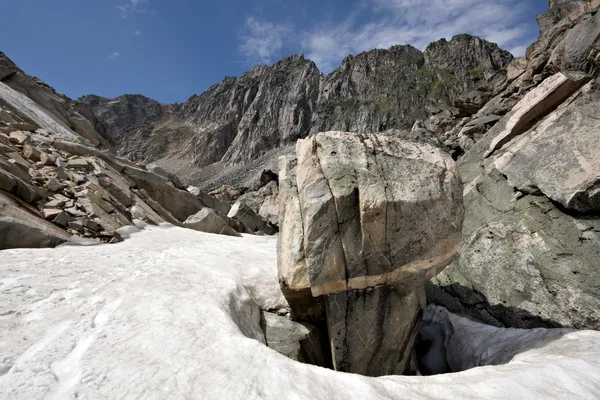 Pedra intricada entre a neve nas montanhas Sayan. Sibéria. Rússia . — Fotografia de Stock