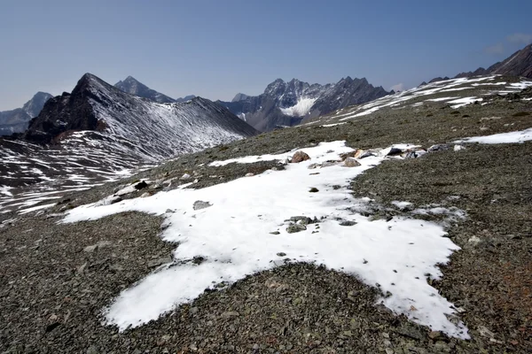 Stenar, snö, moln och himlen i sayan mountains.siberia. — Stockfoto