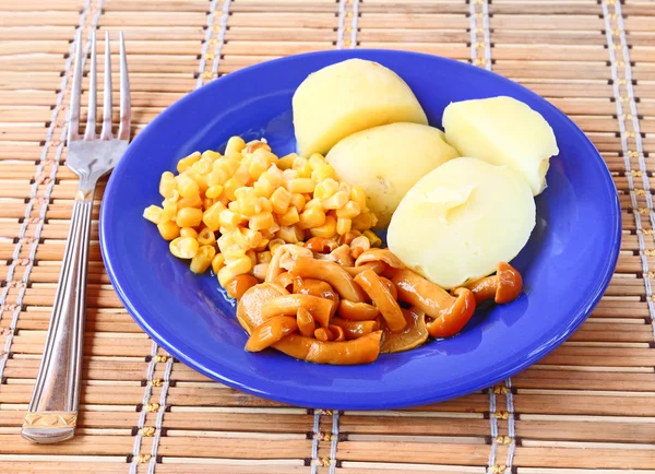 Pilze und Kartoffeln mit einem Mais auf dunkel blau ein Gericht. — Stockfoto