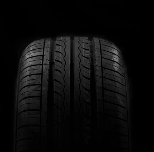 Car tire on black background — Stock Photo, Image