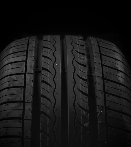 Автомобільна шина на чорному тлі — стокове фото