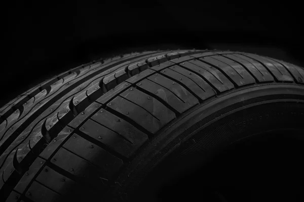 Neumático de coche sobre fondo negro — Foto de Stock