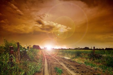 Rural road and dark storm clouds clipart