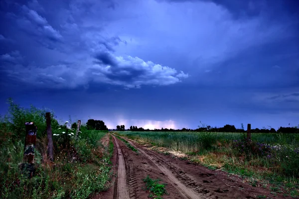 Venkovská silnice a temné bouřkové mraky — Stock fotografie
