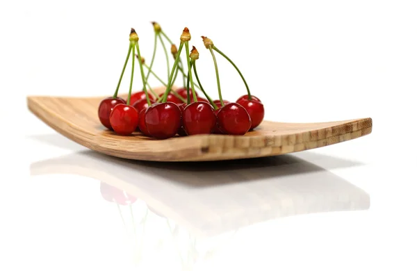 Fresh juicy cherries on wooden plate — Stock Photo, Image