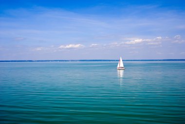 Blue lake with sailboat at summer clipart