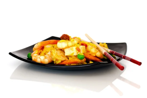 stock image Chopsticks and paella on black plate