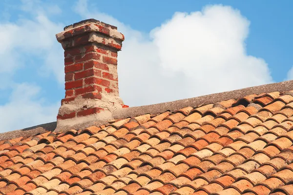 Плитка на крыше с кирпичным дымоходом — стоковое фото