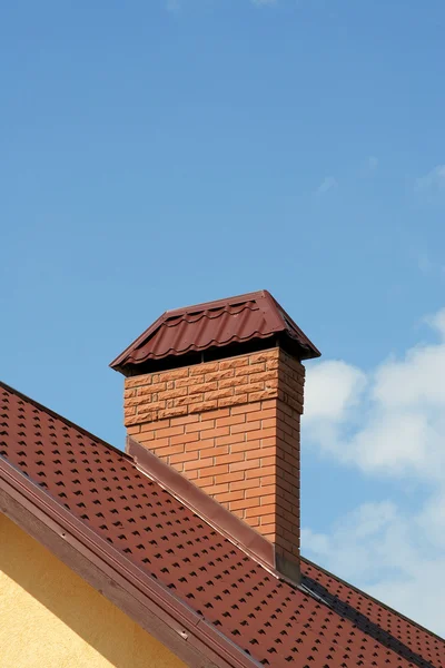 Das Dach eines modernen Hauses mit gemauertem Schornstein — Stockfoto