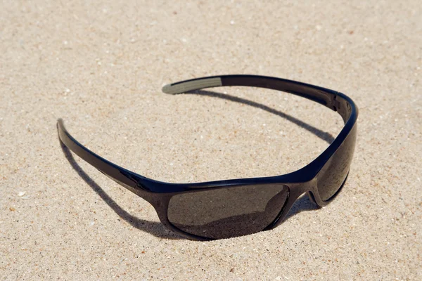 Óculos de sol, deitados na areia — Fotografia de Stock