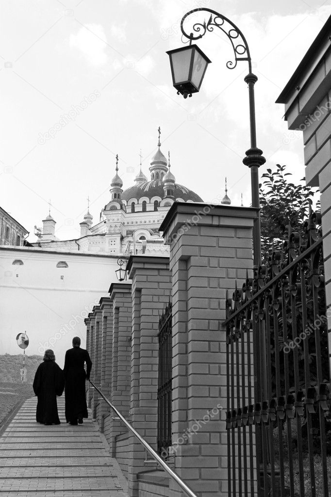Lantern, two priests and church.Kiev-Pechersk Lavra monastery in Kiev. Ukra