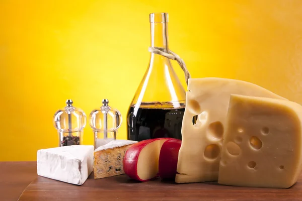 Ser, wino i inne smaczne rzeczy na drewnianym stole — Zdjęcie stockowe