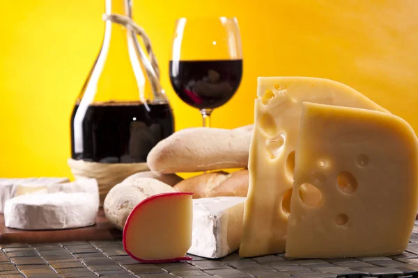 Сыр, вино и другие вкусные вещи на деревянном столе — стоковое фото