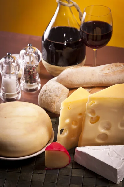 Queijo, vinho e outras coisas saborosas na mesa de madeira — Fotografia de Stock