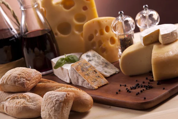 Сир, вино та інші смачні речі на дерев'яному столі — стокове фото