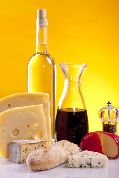 Cheese, wine and other tasty stuff on wooden table — Stock Photo, Image