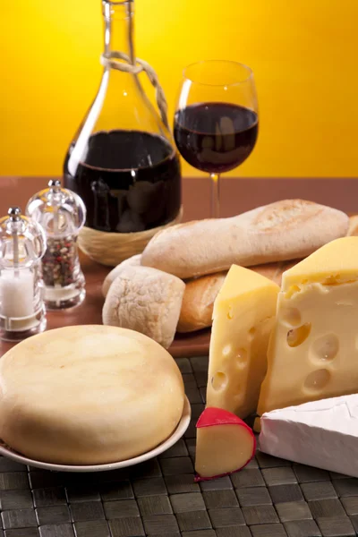 Ser, wino i inne smaczne rzeczy na drewnianym stole — Zdjęcie stockowe