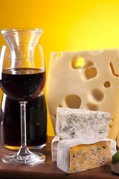 Сир, вино та інші смачні речі на дерев'яному столі — стокове фото
