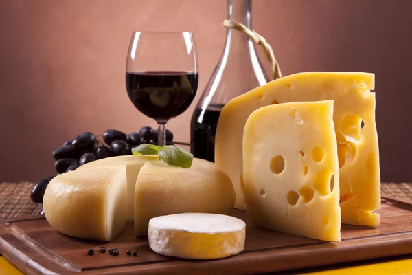 チーズ、ワイン、木製テーブルの上の他のおいしいもの — ストック写真