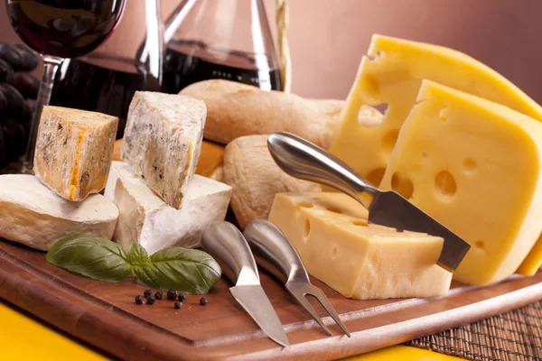 Kaas, wijn en andere smakelijke spullen op houten tafel — Stockfoto
