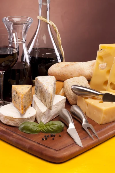 Queijo, vinho e outras coisas saborosas na mesa de madeira — Fotografia de Stock