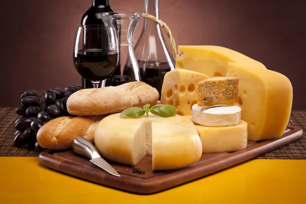 チーズ、ワイン、木製テーブルの上の他のおいしいもの — ストック写真