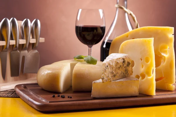 Kaas, wijn en andere smakelijke spullen op houten tafel — Stockfoto