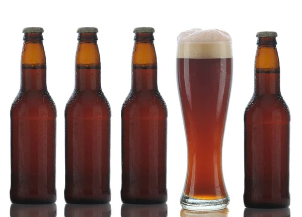 Quatro garrafas de cerveja marrom e vidro completo — Fotografia de Stock