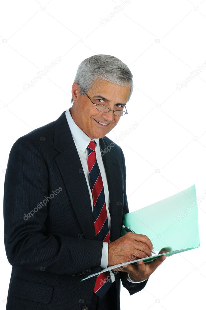 Senior Businessman writing in file