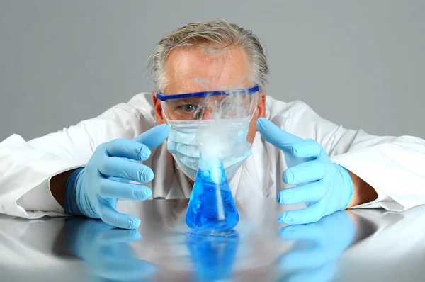 Szalony naukowiec obserwuje jego eksperyment — Zdjęcie stockowe