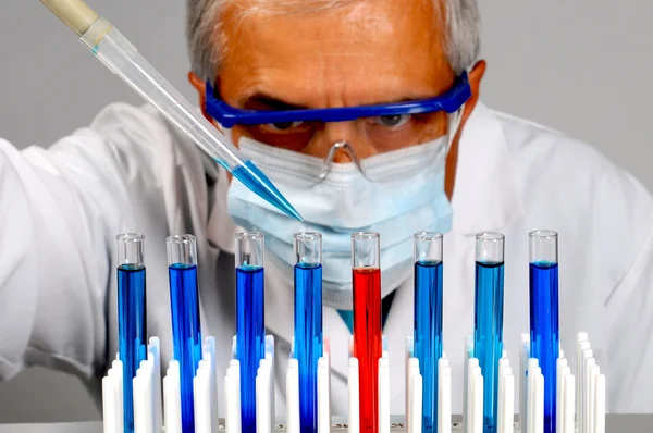 Cientista com tubos de ensaio e pipeta — Fotografia de Stock