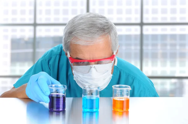 Cientista examinando líquido em copos — Fotografia de Stock