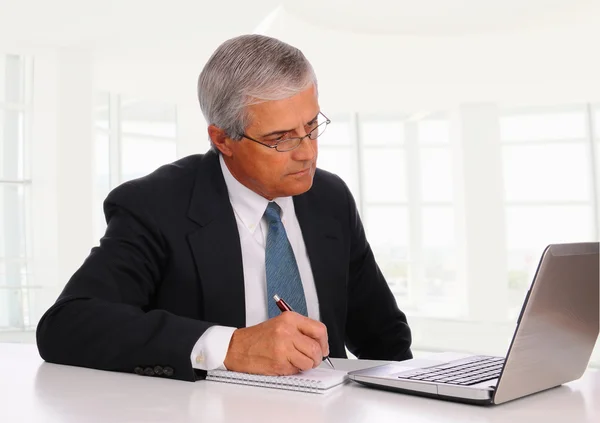 Medelåldern affärsman på skrivbord med laptop — Stockfoto