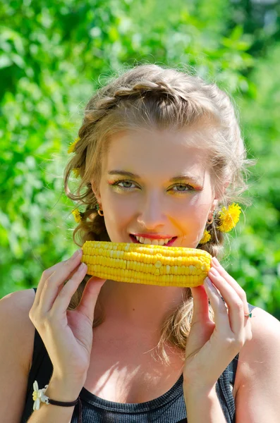 トウモロコシの穂軸を食べる女性 — ストック写真