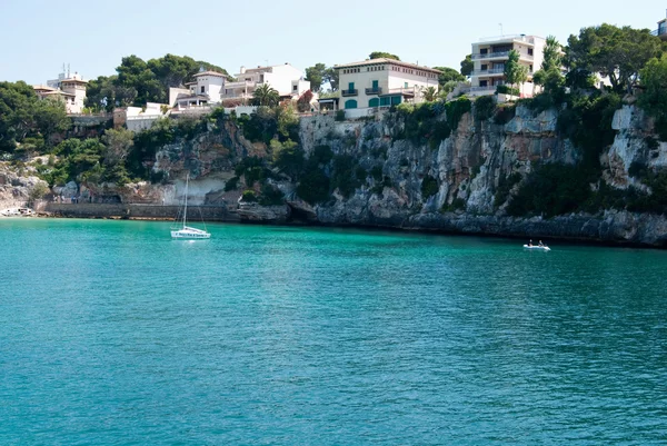 Jacht in der Nähe der felsigen Küste in der Bucht von Porto Cristo, Mallorca, Spanien — Stockfoto