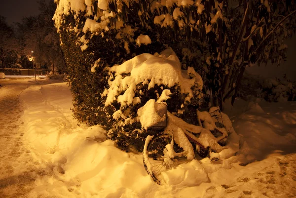 Fiets bedekt met sneeuw in de nacht op lange blootstelling — Stockfoto