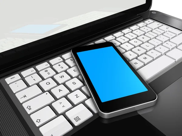 Telefone celular em um laptop — Fotografia de Stock