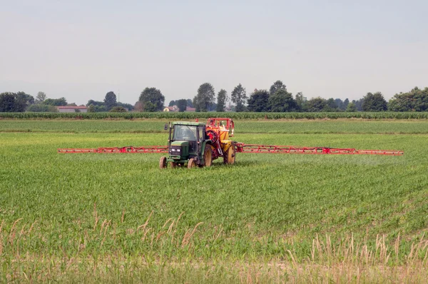 Bewässerung mit dem Traktor auf einem Weizenfeld — Stockfoto