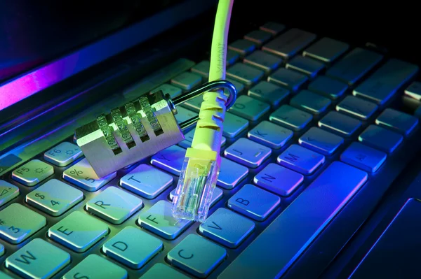 Lock and network cable with computer keyboard background — Stock Photo, Image